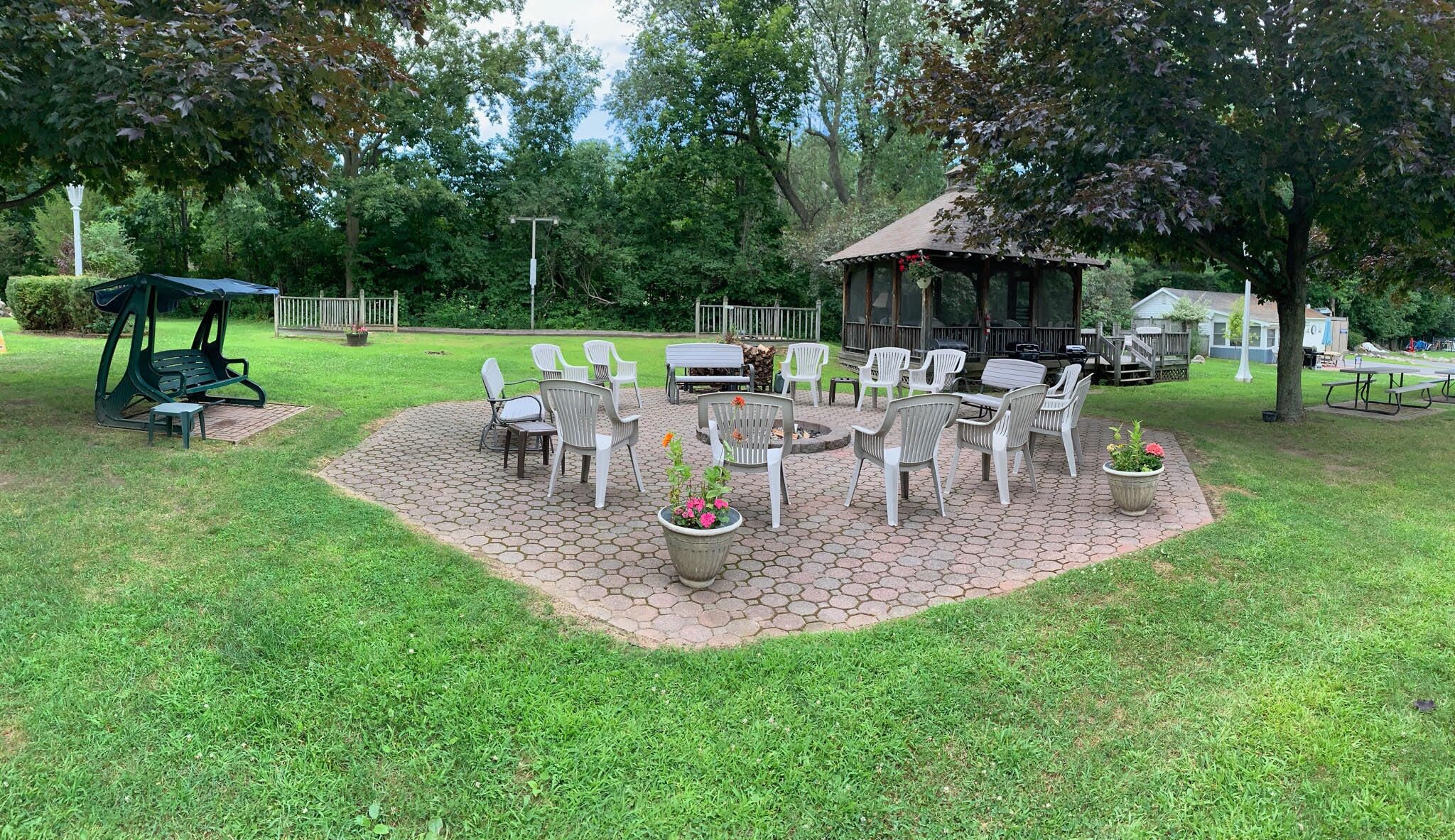 A patio area with outdoor seating, a gazebo, and a fire pit.