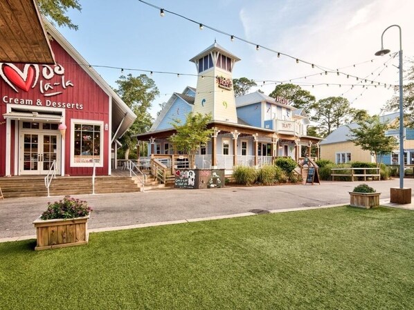 A building with a Cream & Desserts sign, a tower, and string lights.