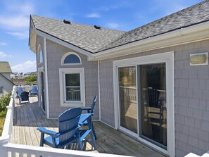 A house with a deck, a sliding glass door, and a small window.
