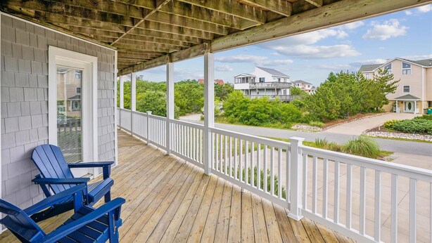 A covered porch with a view of a residential area, including houses and greenery. - 2 min to beach, Private Pool & Hot Tub. Ocean Hill (Corolla)
