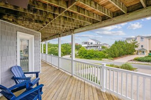 A covered porch with a view of a residential area, including houses and greenery. - 2 min to beach, Private Pool & Hot Tub. Ocean Hill (Corolla)