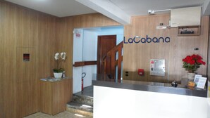 A reception area with a wooden interior, a staircase, and a sign reading "LaCabanas". - Apart Hotel La Cabana (Florianópolis)