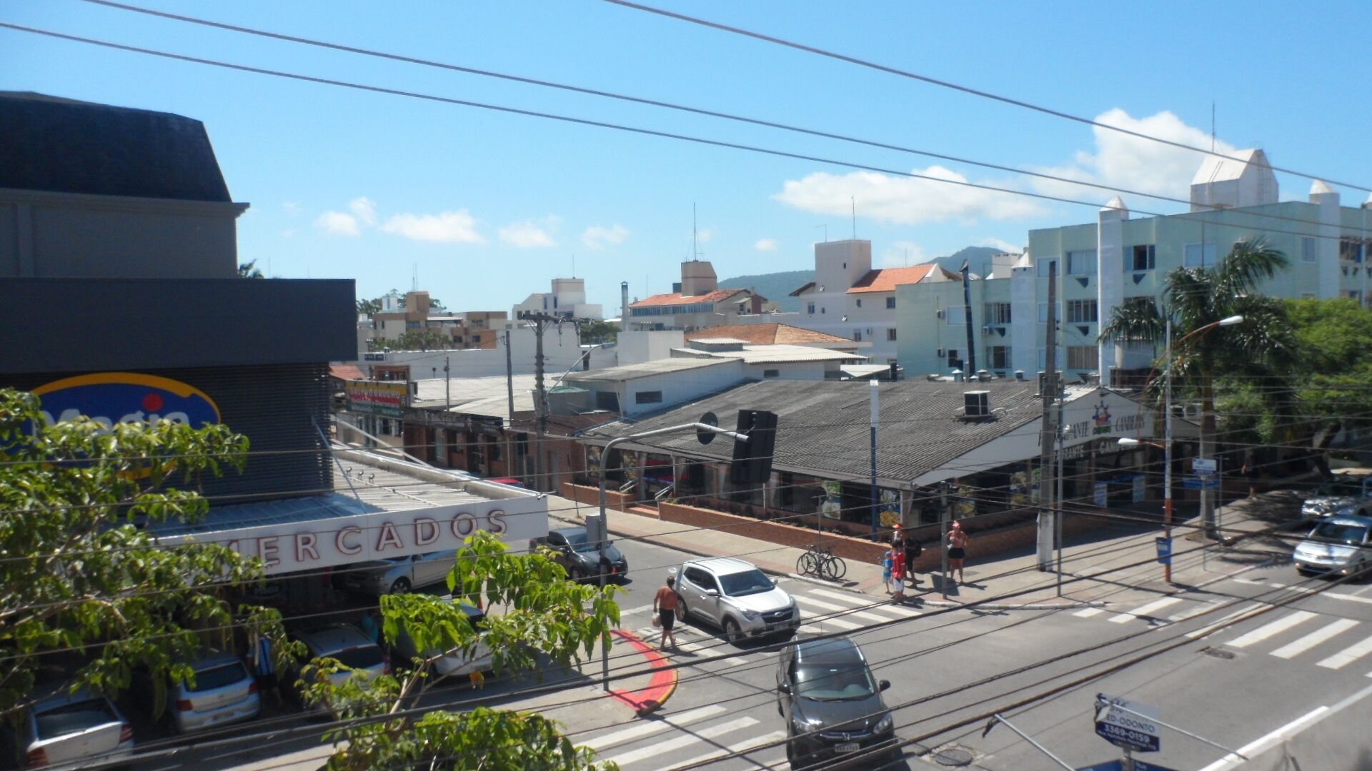 A street view with buildings, a crosswalk, and vehicles.