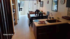 Una cocina moderna con comedor, que incluye un fregadero, armarios y una mesa con sillas.