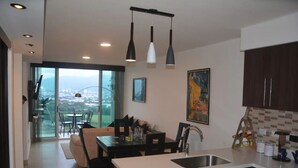 Una cocina moderna con comedor, ventanas amplias y vista a la ciudad.