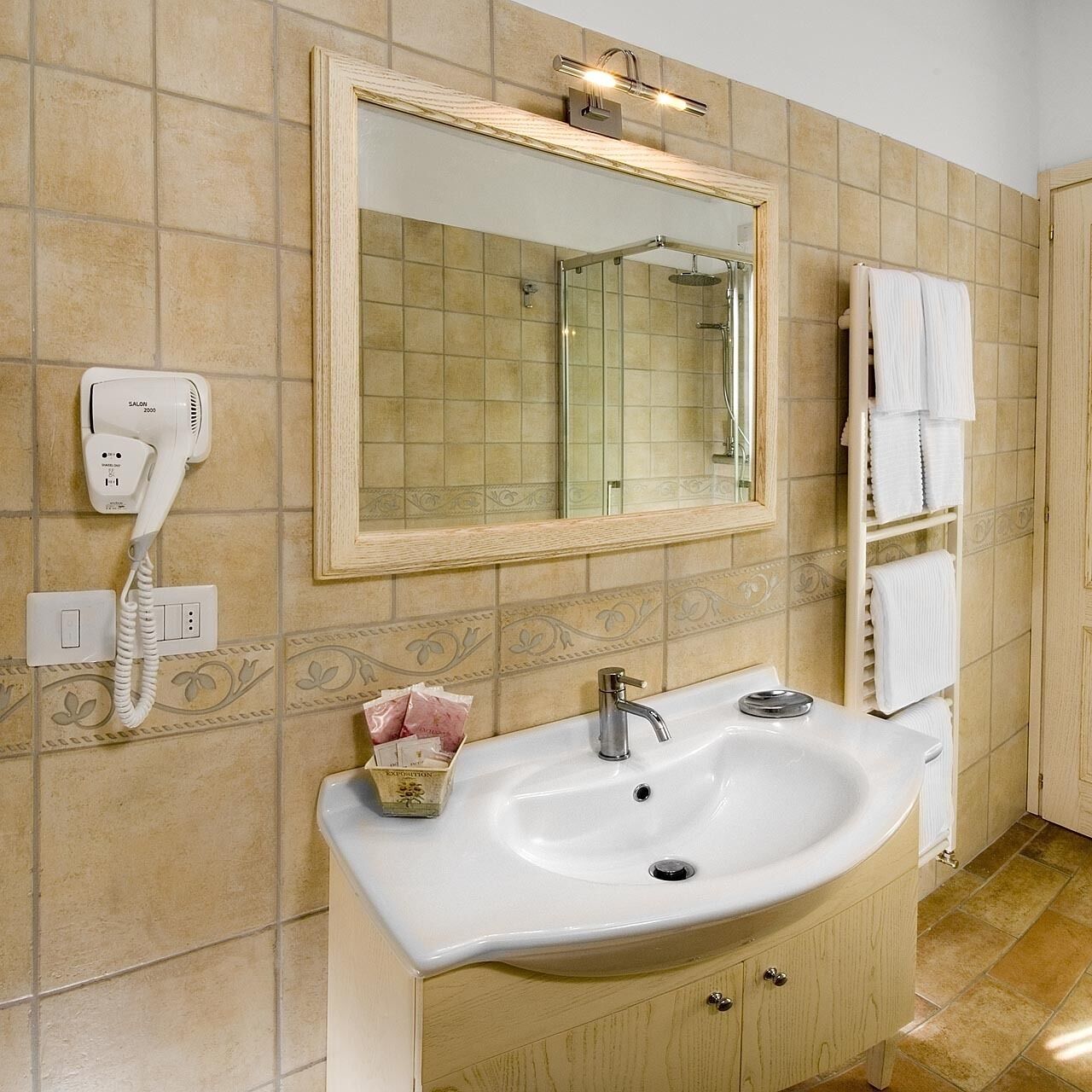A bathroom with a sink, mirror, and towel rack.