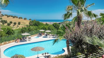 Een seizoensgebonden buitenzwembad en parasols bij het zwembad