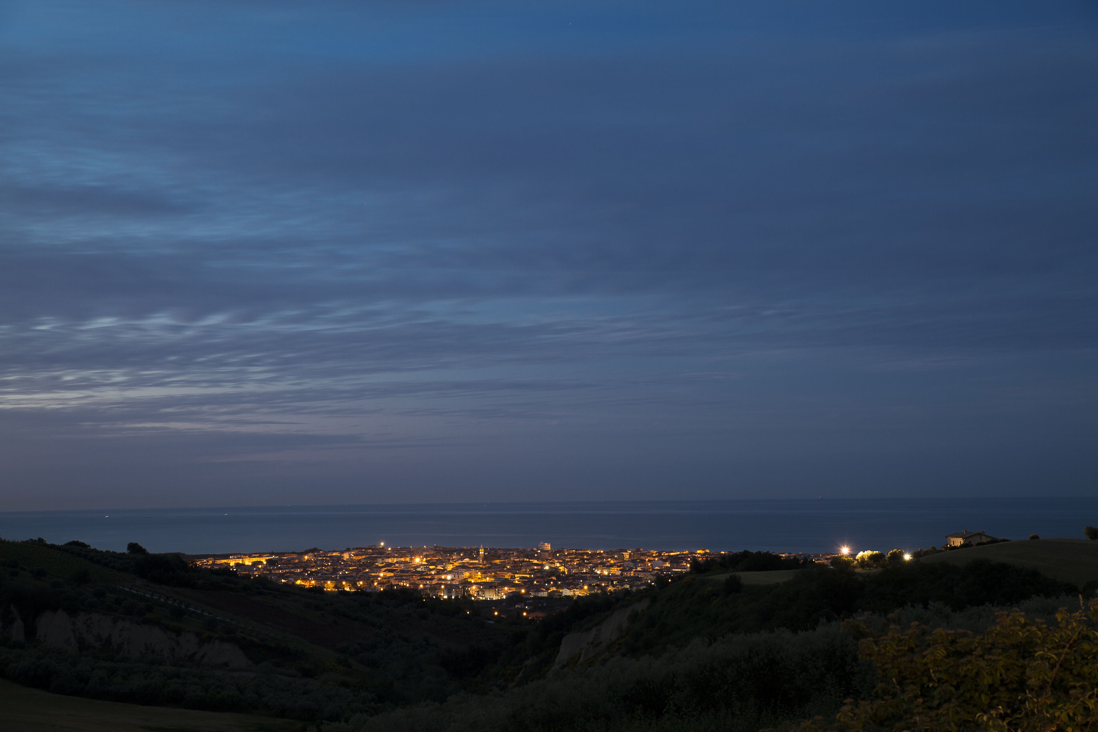 A nighttime cityscape with a view of the coastline.