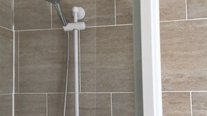 Ducha con cabezal de ducha de mano y llave de control de pared.
