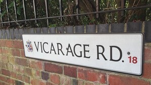 Una señal de calle indica la calle Vicarage, número 18.