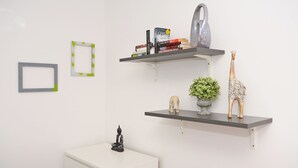 A room with a white desk, two shelves with decorative items, and a framed picture on the wall. - Townhouse Plus @ 301 West Street Crewe (Crewe)