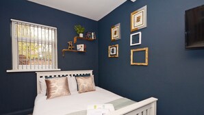 A bedroom with a bed, a window, and wall-mounted shelves with books and a plant. - Townhouse Plus @ 301 West Street Crewe (Crewe)