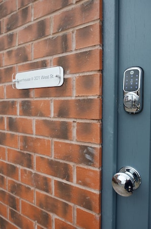 Une porte dotée d’un clavier pour ouvrir à l’aide d’un code et d’une plaque indiquant l’adresse : 301, rue West.