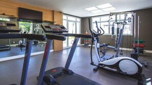 A gym with cardio machines, weight equipment, and large windows. - Apartment next to the Grêmio Arena (Farrapos)