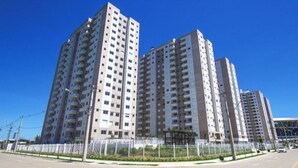 A modern high-rise residential building with multiple balconies, a parking lot, and a stadium in the background. - Apartment next to the Grêmio Arena (Farrapos)