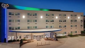 A multi-story hotel with a flat facade, a covered entrance, and a parking lot.