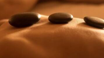 Close-up van een massage met stenen op een rug.