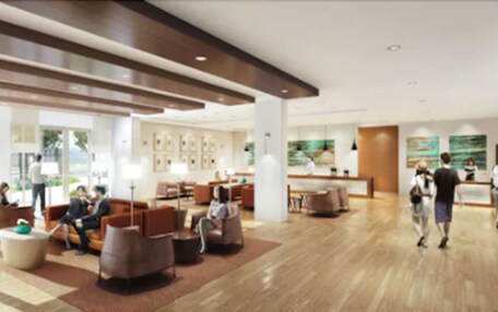 A modern hotel lobby with seating areas, a reception desk, and artwork on the walls.