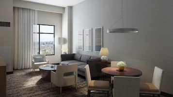 A hotel room with a sofa, two armchairs, a small table, a lamp, and a view of the city through a large window.