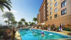 A hotel with a swimming pool surrounded by palm trees and lounge chairs. - Estrella at Casino Del Sol (Tucson)