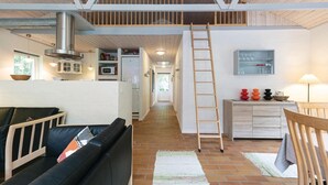 Um interior moderno com um quarto no mezanino, cozinha e sala de estar.