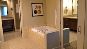 Bathroom features a bathtub, large mirror, and artwork.