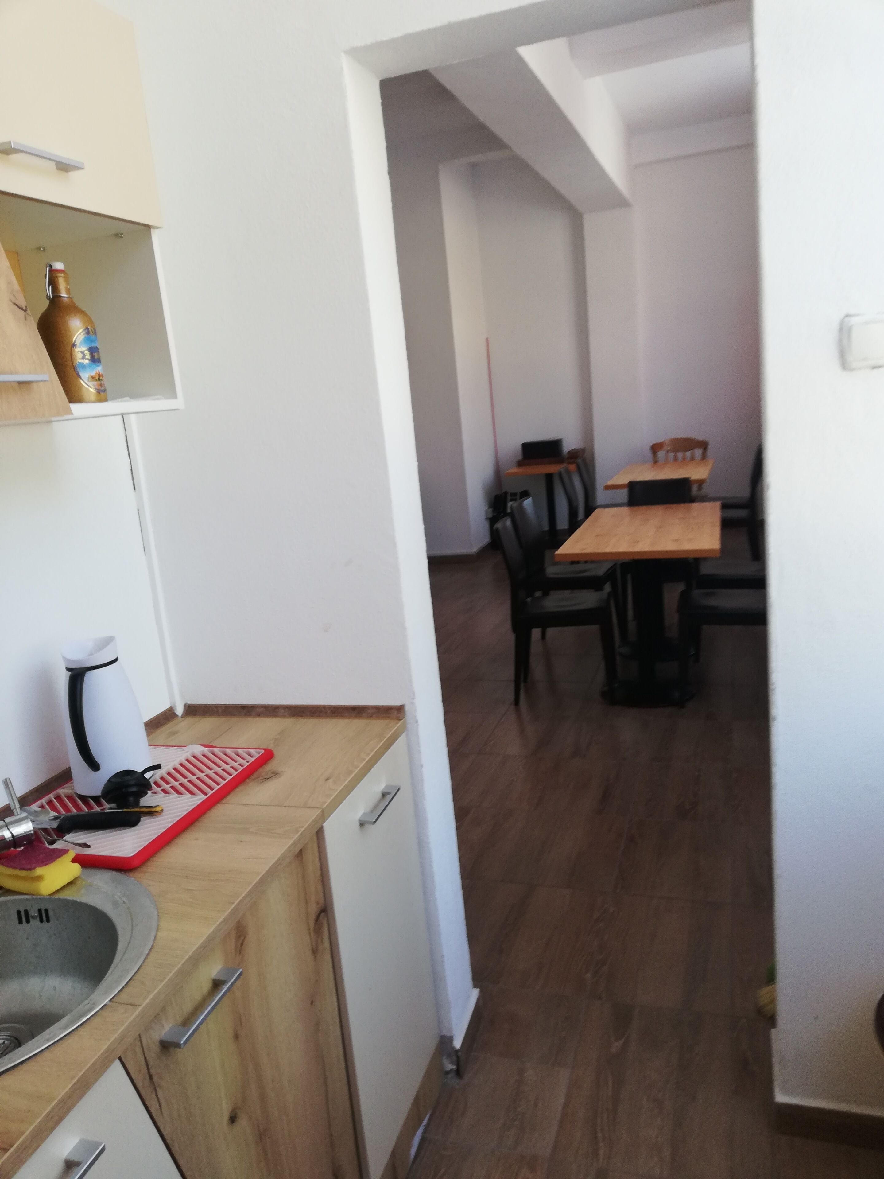 Eine moderne Küche mit Holzausstattung, einem Spülbecken und einer Essecke mit Tisch und Stühlen.