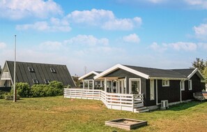 Et moderne hus med skråtag, en overdækket veranda og en lukket have.