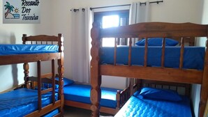 Ein Zimmer mit drei Etagenbetten, jeweils mit blauer Bettwäsche. An der Wand ist ein Schild mit der Aufschrift 'Recanto Dos Teixeira'.