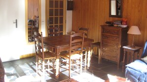 A dining area with a wooden table and chairs, a dresser, and a mirror on the wall.