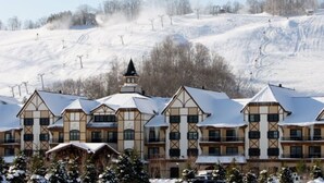 Un hotel de varios pisos con estilo arquitectónico tradicional, que destaca por una torre prominente y varios balcones.