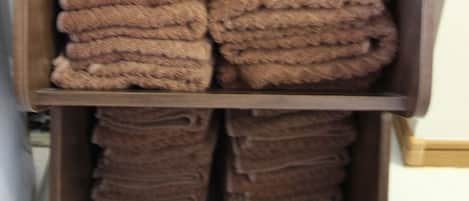 Un cajón con toallas marrones ordenadas.