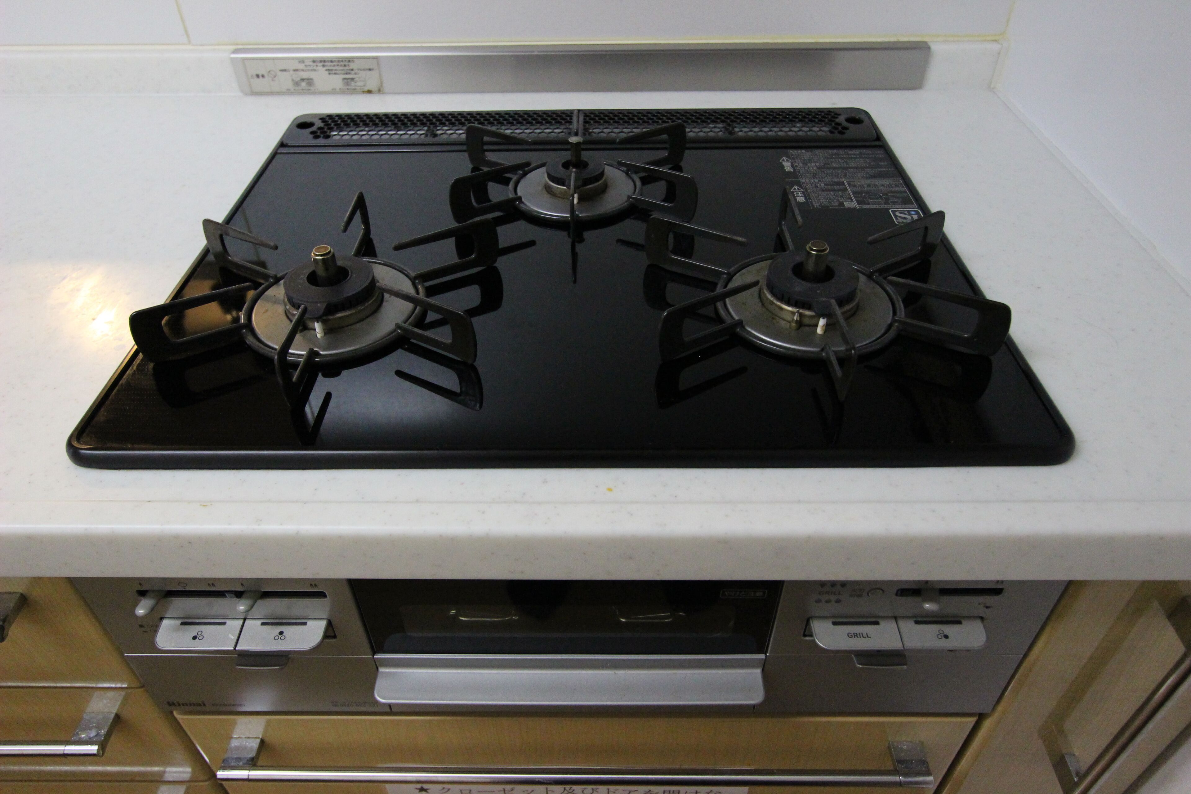 A kitchen with a four-burner gas stove, a microwave, and a built-in oven.