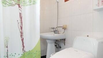 A bathroom with a toilet, sink, and shower.