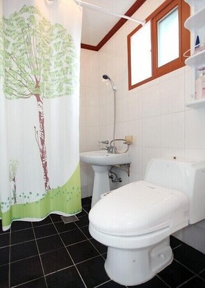 A bathroom with a toilet, sink, and shower.