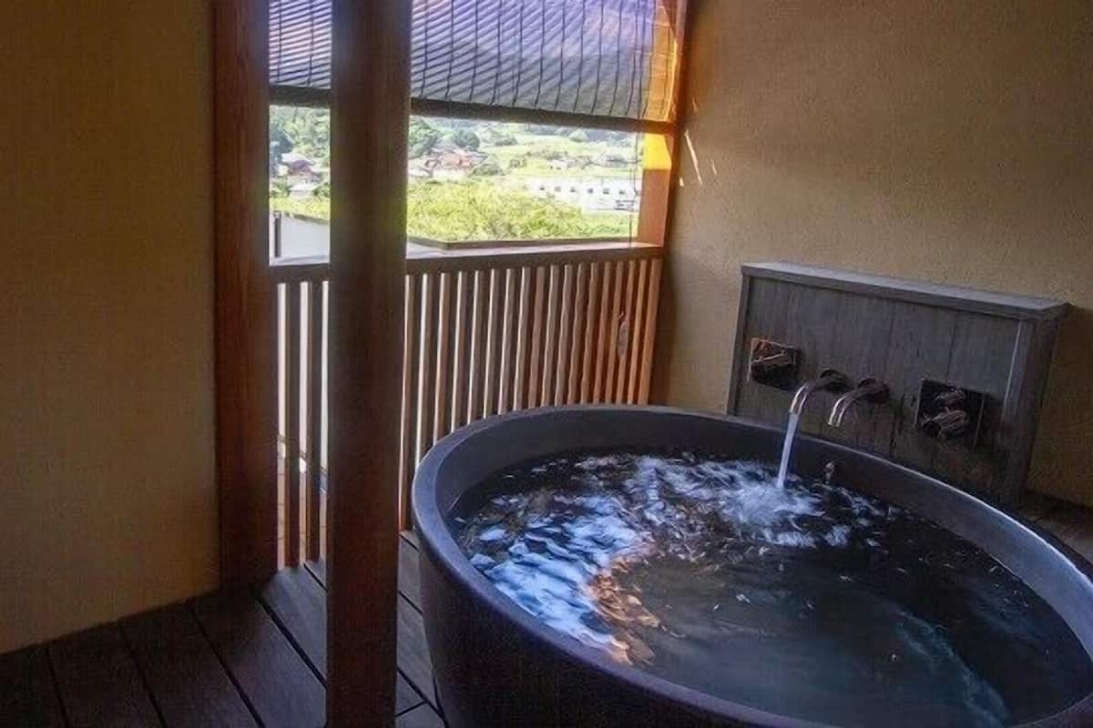 Un jacuzzi en una habitación con vistas a zonas verdes.