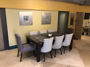 Una sala conferenze con un tavolo rettangolare, sei sedie e due opere d'arte appese al muro.