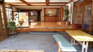 A traditional Japanese interior with tatami flooring, a low wooden table, and a sliding door. - Resort House FURUSATO (Nozawaonsen)