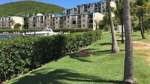 Un hotel amb diverses plantes, un port esportiu i palmeres.