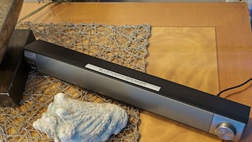 Puupinnalla oleva Bluetooth-kaiutin, jonka päällä on verkko ja kuori.
