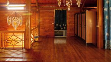 A wooden interior with a wooden floor, a doorway with a curtain, and a hanging dreamcatcher.