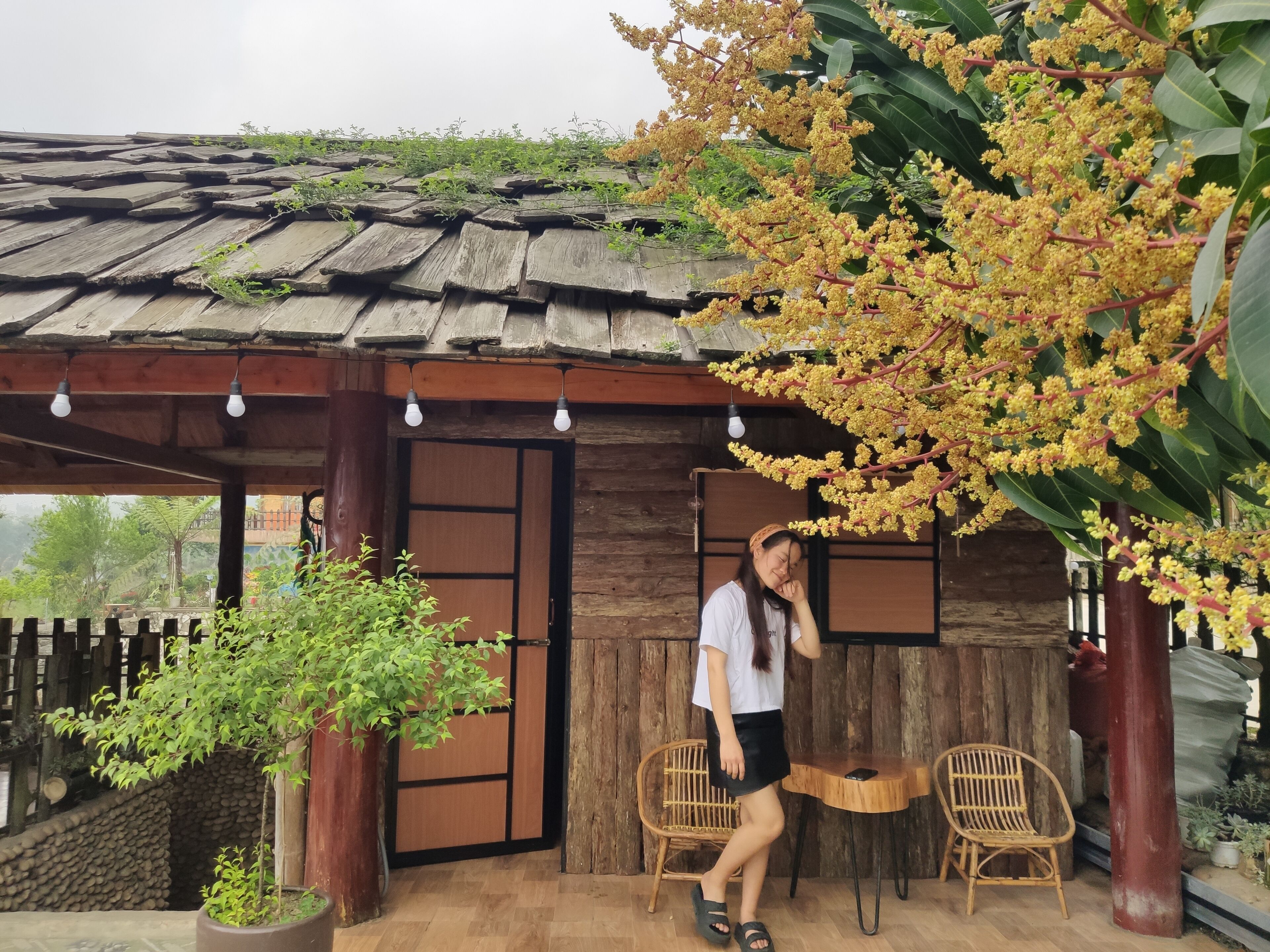 A rustic wooden structure with a tiled roof, a wooden door, and a small table with chairs.