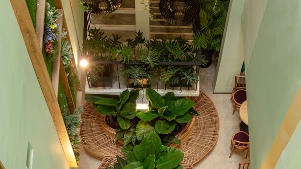 An indoor space with a central seating area, surrounded by lush greenery and plants. - Dai Nam Sai Gon Hotel (Ho Chi Minh City)