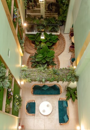 An indoor space with a central seating area, surrounded by lush greenery and plants. - Dai Nam Sai Gon Hotel (Ho Chi Minh City)