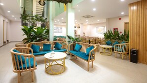 A spacious lobby with wicker furniture, a central round table, and large potted plants. - Dai Nam Sai Gon Hotel (Ho Chi Minh City)