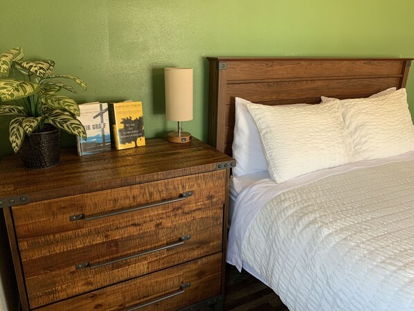 Un aparador de madera con cajones, una planta en maceta y dos libros.