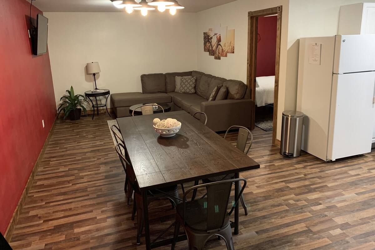 A compact living space with a dining table, sofa, and a kitchenette.