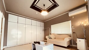 Un salon moderne avec un canapé blanc, une table basse et une grande armoire.