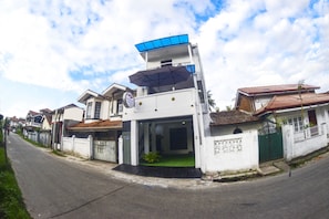 Un bâtiment moderne à deux étages, doté d’un toit plat et d’un grand parasol au-dessus de l’entrée.
