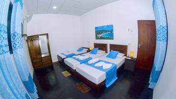 A hotel room with two beds, a wooden wardrobe, a painting on the wall, and a door.